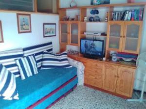 een woonkamer met een bank en een tv bij Atico en La Aldea de San Nicolas in San Nicolás