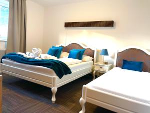 Appartements-Dalila في سانكت مايكل ايم لونغاو: غرفة نوم بسريرين مع وسائد زرقاء
