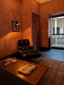 - un salon avec un fauteuil en cuir et une table dans l'établissement Riad Alena, à Marrakech