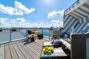 a deck with a couch and a table on a boat at Schwimmendes Haus Hygge Olpenitz in Olpenitz
