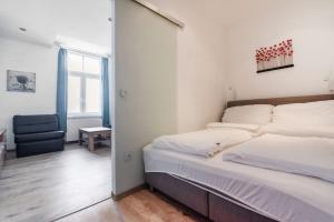 ein Schlafzimmer mit einem großen Bett und einem Stuhl in der Unterkunft Lovely serviced apartment Vienna 3km to DT+Balcony in Wien