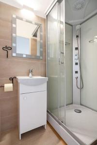 ein Bad mit einer Dusche, einem Waschbecken und einem Spiegel in der Unterkunft Lovely serviced apartment Vienna 3km to DT+Balcony in Wien