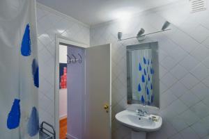 a white bathroom with a sink and a mirror at FLH Norte Place in Lisbon