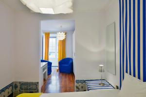 リスボンにあるFLH Norte Placeのベッドルーム1室(ベッド1台、青い椅子付)