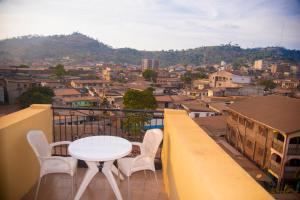 a table and chairs on a balcony overlooking a city at Appartement meublé 2 chambres avec salle de bain - 1 salon - 1e cuisine - La Concorde - Quartier Nkomkana in Yaoundé