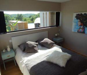 Schlafzimmer mit einem Bett und einem großen Fenster in der Unterkunft Splendide Villa ESTEVE piscine démesurée proximité Sarlat in Sainte-Mondane