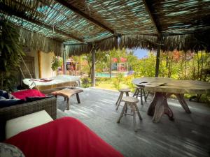 a patio with a table and chairs and a view of a yard at Xainã Pousada de Charme in Cumbuco