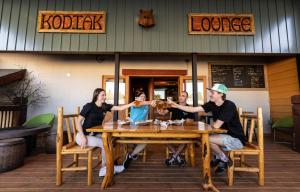 a group of people sitting at a table at a restaurant at The Raging Elk Adventure Lodging in Fernie