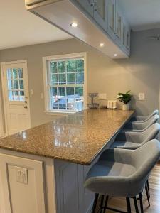 Una cocina con un mostrador con sillas alrededor. en Lux Family Xcape with HotTub Fireplace Deck BBQ, en Silver Spring