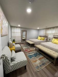 una sala de estar con dos camas y un sofá en Lux Family Xcape with HotTub Fireplace Deck BBQ, en Silver Spring
