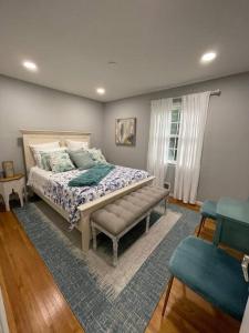um quarto com uma cama com um banco e uma janela em Lux Family Xcape with HotTub Fireplace Deck BBQ em Silver Spring