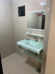 La salle de bains est pourvue d'un lavabo et d'un miroir. dans l'établissement España Suites Hotel, à Ciudad del Este