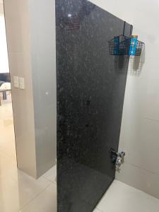 cabina de ducha con puerta negra en una habitación en España Suites Hotel, en Ciudad del Este
