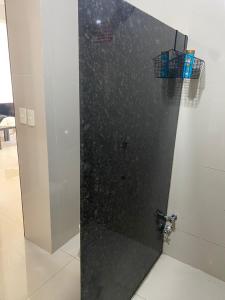 box doccia con porta nera in una stanza di España Suites Hotel a Ciudad del Este