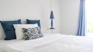 a white bed with blue pillows in a bedroom at Casa S Tomè Nago Torbole in Nago-Torbole