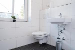 a white bathroom with a toilet and a sink at Buer Appartment in Gelsenkirchen