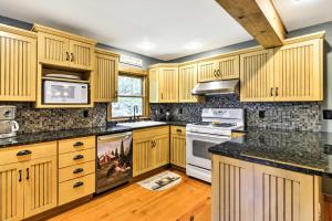 una cocina con armarios de madera y encimeras negras en Black Mountain Cabin with Screened Porch and Views!, en Black Mountain