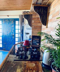 uma cozinha com um fogão e um liquidificador no balcão em Praia Itápiruba 600m - WI-FI 800Mg - 1,5km BR 101 - Espaço comp - Varanda c Pôr do sol em Imbituba