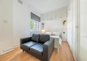 a living room with a couch and a bed at Spacious Cricklewood Apartment sleeps 4 in London