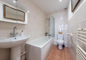 a white bathroom with a sink and a toilet at Spacious Cricklewood Apartment sleeps 4 in London