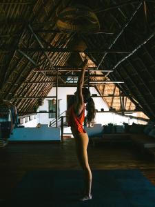 Uma mulher está debaixo de um tecto com os braços para cima. em Casa Zala em El Paredón Buena Vista