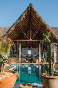 um resort com uma piscina e um telhado de palha em Casa Zala em El Paredón Buena Vista