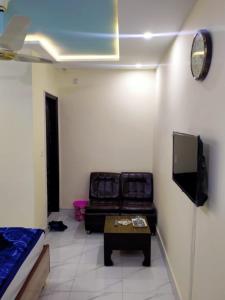 a living room with a couch and a tv at Hotel new royal palace in Lahore