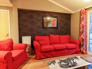 a living room with a red couch and a mirror at Washburn Lodge in Harrogate