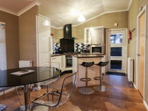a kitchen with a glass table and chairs in it at Washburn Lodge in Harrogate