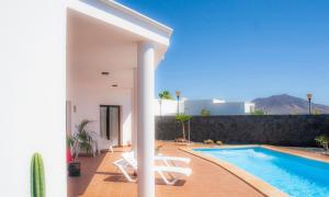 a villa with a swimming pool and a house at El jardín de Juanita - ROOMS in Playa Blanca