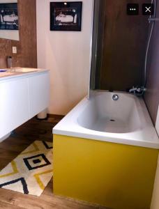a bathroom with a yellow and white bath tub at Pou-Spa in Spa +11 photos