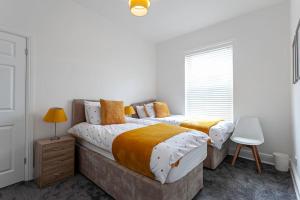 1 dormitorio con 2 camas y ventana en Spacious Comfortable house close to Etihad+parking en Mánchester