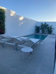 a pool with benches and a table on a building at Cap-Canaria FKK in San Bartolomé de Tirajana