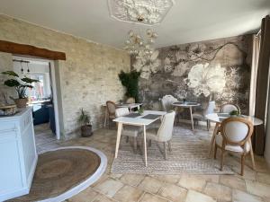 uma sala de jantar com mesas e cadeiras e uma parede em Aurefees em Ellon