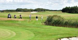 un gruppo di persone che giocano a golf su un campo da golf di Chalet2rent Ameland a Ballum