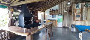 un bar con chimenea en una habitación con mesa de billar en Pousada Além do Mar, en Praia do Rosa
