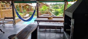 un patio con hamaca, mesa y sillas en Pousada Além do Mar, en Praia do Rosa