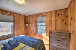 a bedroom with a bed and a dresser and two windows at Updated Bristol Lakehouse with Kayaks and Beach Access in Bristol
