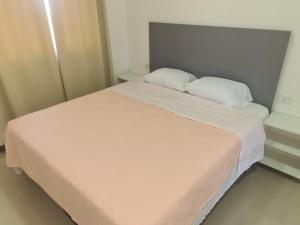 Una cama con dos almohadas blancas encima. en VICTORIA SUITES APRT.HOTEL, en Encarnación