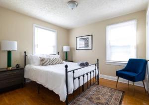 um quarto com uma cama e uma cadeira azul em Spacious 2BR Home In Kentucky em Louisville