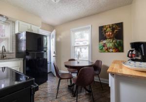 uma cozinha com uma mesa e um frigorífico preto em Spacious 2BR Home In Kentucky em Louisville