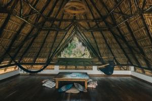 een kamer met een tafel en hangmatten bij Casa Zala in El Paredón Buena Vista