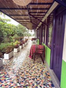 um pátio com um piso colorido com uma mesa e cadeiras em Finca Hostal La Esperanza em Quimbaya