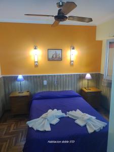 a bedroom with a blue bed with towels on it at Hotel Sahara in Villa Gesell