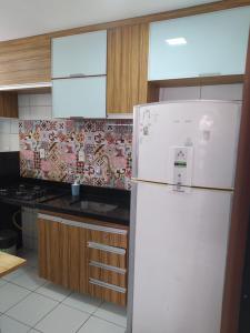 eine Küche mit einem weißen Kühlschrank und einem Herd in der Unterkunft AP 201 Acolhedor situado na Zona Leste, com 3 quartos sendo 1 suíte in Teresina