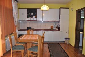 a kitchen with a table and chairs and a kitchen with white cabinets at Guest House Majstorovic in Banja Luka