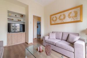 a living room with a couch and a tv at Boutique Apartment with ParkView in Heraklio Town