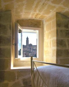 a bedroom with a window with a view of a building at Casa Vittoria in Matera