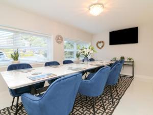 a large conference room with a long table and blue chairs at 4 Woodland Park in Bideford