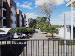 un estacionamiento con autos estacionados al lado de un edificio en AP 201 Acolhedor situado na Zona Leste, com 3 quartos sendo 1 suíte en Teresina